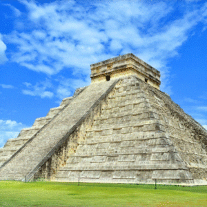 A mesmerizing view of the ancient ruins of Chichen Itza against a backdrop of lush greenery.